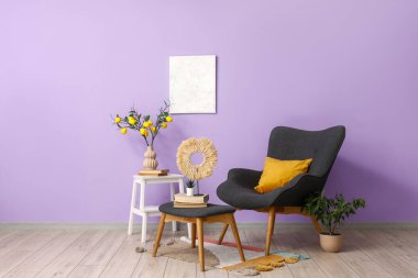 Koltuk, merdiven ve ev bitkileri oturma odasının iç kısmında, menekşe duvarının yanında.