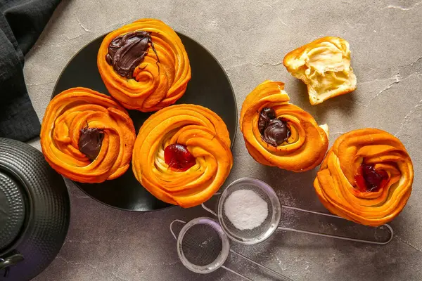 Gri arka planda çikolata ve reçelli lezzetli kabuklar.