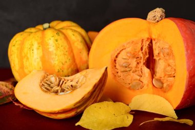 Taze balkabakları ve sonbahar yaprakları kırmızı masada.