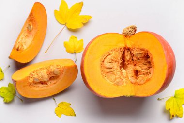 Gri arkaplanda taze balkabağı ve sonbahar yaprakları kes