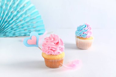 Masada beyaz arka planda süslemeleri olan enfes kekler. Cinsiyet ortaya çıkan parti kavramı