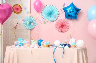 Bebek poposu ve masa üzerinde pembe arka planda süslemeleri olan enfes kekler. Cinsiyet ortaya çıkan parti kavramı