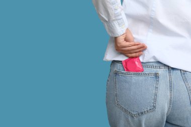 Renkli arka planda prezervatifli kadın