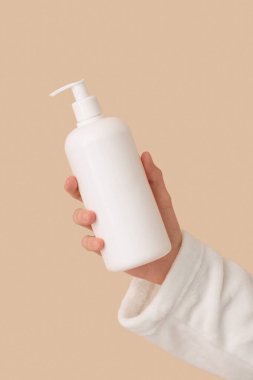 Arka planda doğal krem şişesi tutan kadın, yakın plan.