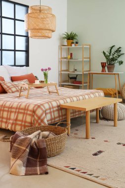 İçinde yatak, pencere, raf ünitesi ve laleli tepsi olan rahat bir yatak odası.