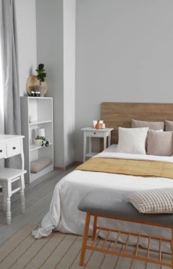 Büyük yataklı, raflı ve komodinli modern yatak odası.