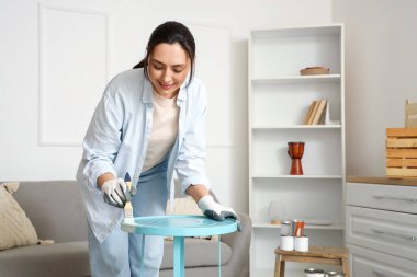 Evde resim yapan genç bir kadın.