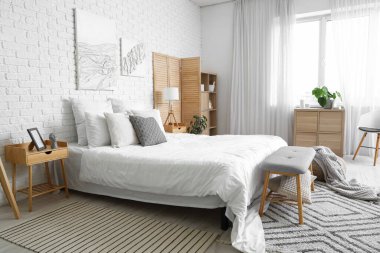 Modern ışık yatak odasının içinde büyük rahat bir yatak ve bank.