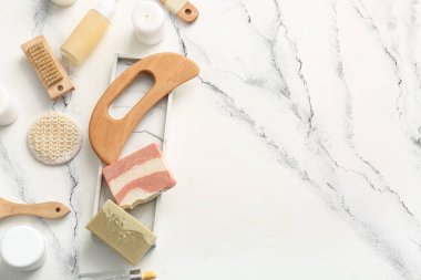 Ahşap guasha vücut masajı aracı, sabun çubuğu ve mermer arka plan fırçaları ile kompozisyon
