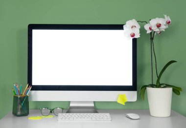 Ofisinde ev bitkisi, kırtasiye ve modern bilgisayarı olan şık bir iş yeri.