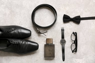 Beyaz grunge arka planda ayakkabı, kemer ve gözlük takan erkek aksesuarları. Üst görünüm