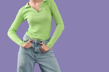 Mor arka planda şık kotlu güzel bir kadın, yakın plan.