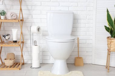 Tuvaletin içinde klozet ve raf ünitesi var.