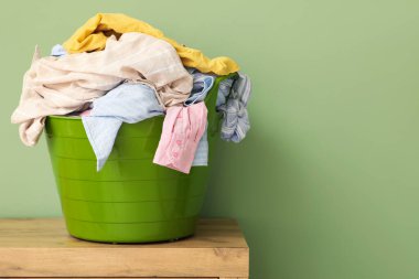 Yeşil duvarın yanındaki çekmecelerde çamaşır sepeti.