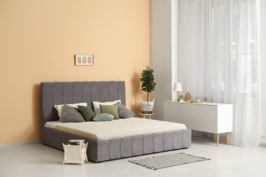 Yatak odasında rahat bir yatak ve çekmeceler.