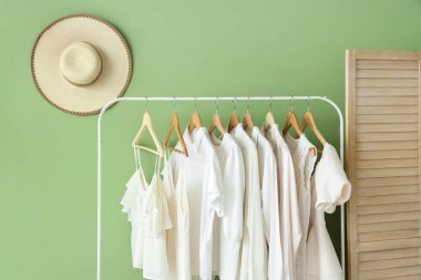 Yeşil duvarın yanındaki beyaz elbiseli rafta.