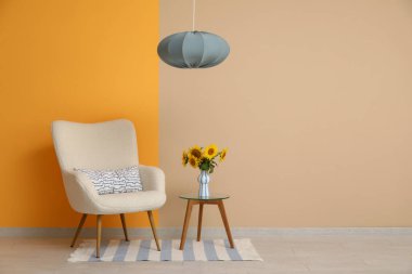 Oturma odasındaki masada güzel ayçiçekleri olan koltuk ve vazo.