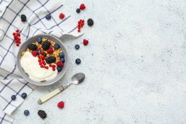 Hafif arkaplanda yoğurt bulunan bir kase lezzetli granola.