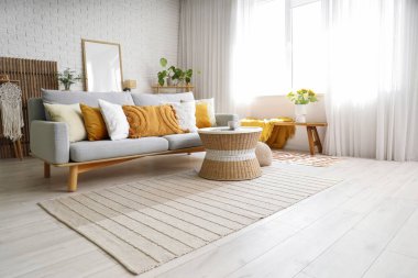 Kanepesi ve masası olan modern aydınlık oturma odasının içinde.