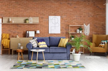 Oturma odasının içinde mavi kanepe, koltuk ve palmiye ağaçları var.