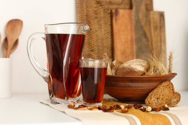 Mutfaktaki masada ekmekli bir sürahi ve bir bardak lezzetli kvass.