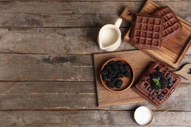 Tahta arka planda taze böğürtlen, yabanmersini ve sütle Belçika usulü tatlı waffle tahtaları.
