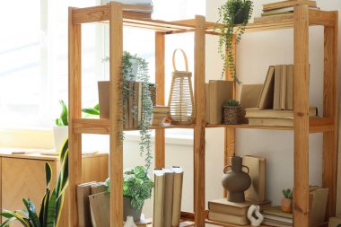 Odanın içinde dekorlu, çiçekli ve kitaplı raf ünitesi