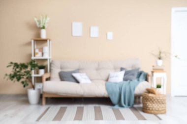 Koltuk, dekore edilmiş ağaç, raf ünitesi ve oturma odasının içindeki kitapla puf. Bulanık görünüm