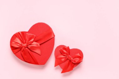 Pembe arka planda kalp şeklinde hediye kutuları. Sevgililer Günü kutlaması
