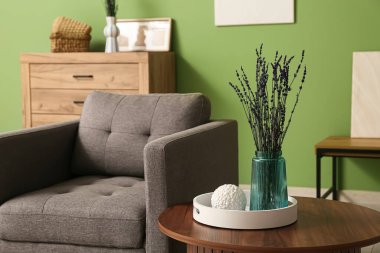 Oturma odasındaki masada lavanta çiçekli vazo.