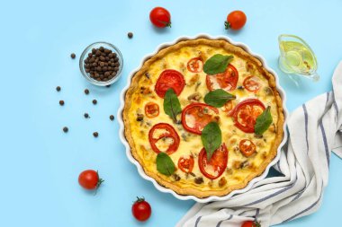 Ispanak yapraklı lezzetli domates tartı ve mavi arka planda biber.