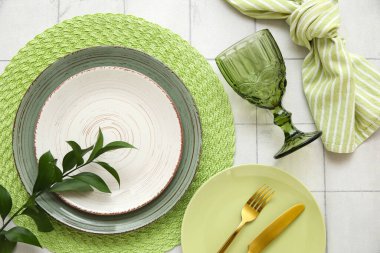 Beyaz seramik zemin üzerinde taze yeşil yapraklar ile güzel masa ayarları