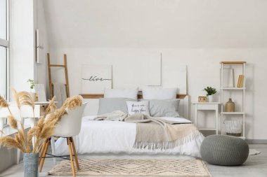 Konforlu yatak odası, puf ve pencerenin yanındaki çalışma alanı