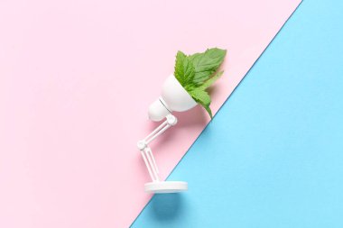 Arka planda bitki yaprakları olan lamba. Yeşil teknoloji kavramı