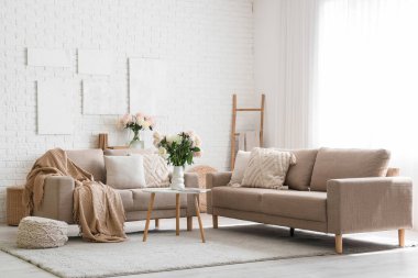 Gri koltukları, kahve masası ve güzel şakayıkları olan şık bir oturma odası.