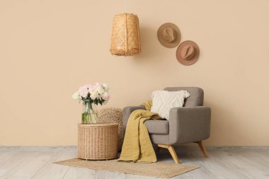 Gri koltuğu, hasır sehpası ve güzel şakayıkları olan şık bir oturma odası.