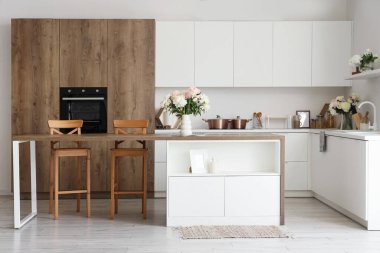 Ada masası ve güzel şakayıkları olan şık bir mutfak.