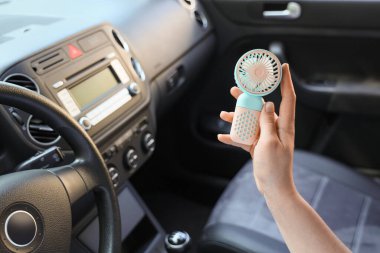 Arabada vantilatörü olan genç bir kadın, yakın plan.