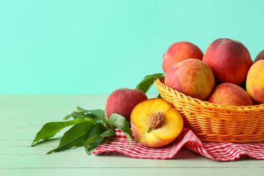 Turkuaz arka planda taze şeftali sepeti.