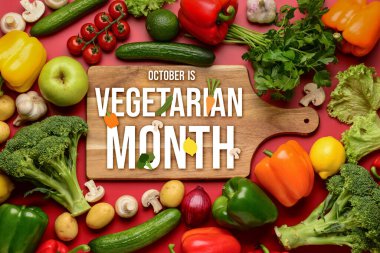 Taze sebzeli ahşap tahta, kırmızı arka planda meyve ve mantar.