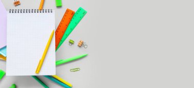 Boş not defteri ve gri arkaplan üzerinde farklı kırtasiye malzemesi metin için boşluk