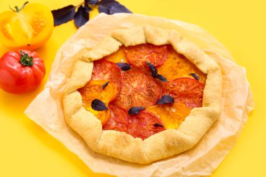 Lezzetli domatesli kağıt ve sarı arka planda fesleğen.