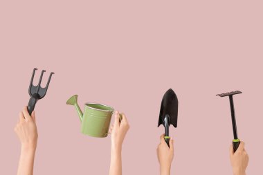Pembe arka planda farklı bahçe aletleri olan kadınlar.