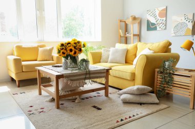 Interior of living room with sunflowers in vase on table