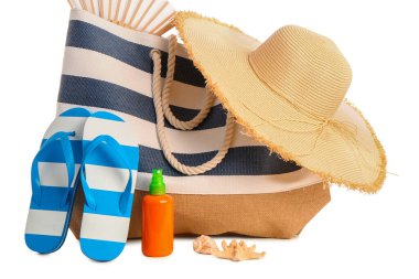 Beyaz arka planda izole edilmiş plaj aksesuarlarıyla bir şişe güneş kremi.