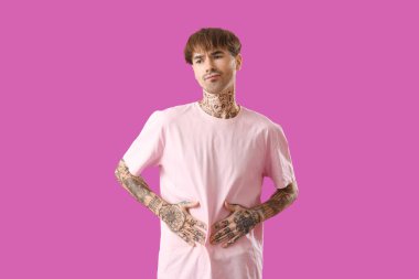 Mor arka planda karın ağrısı çeken genç bir adam.