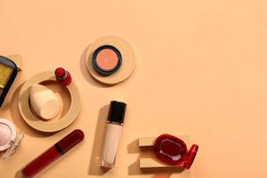 Turuncu arka planda farklı dekoratif kozmetik ürünleri var.