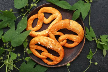 Yumuşak simit tabağı ve siyah zemin üzerinde hop yaprakları