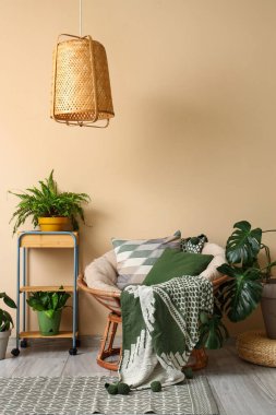 Oturma odasının içinde yeşil bitkiler ve koltuk var.