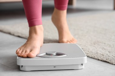 Genç bir kadın ağırlığını evde ölçecek. Diyet kavramı